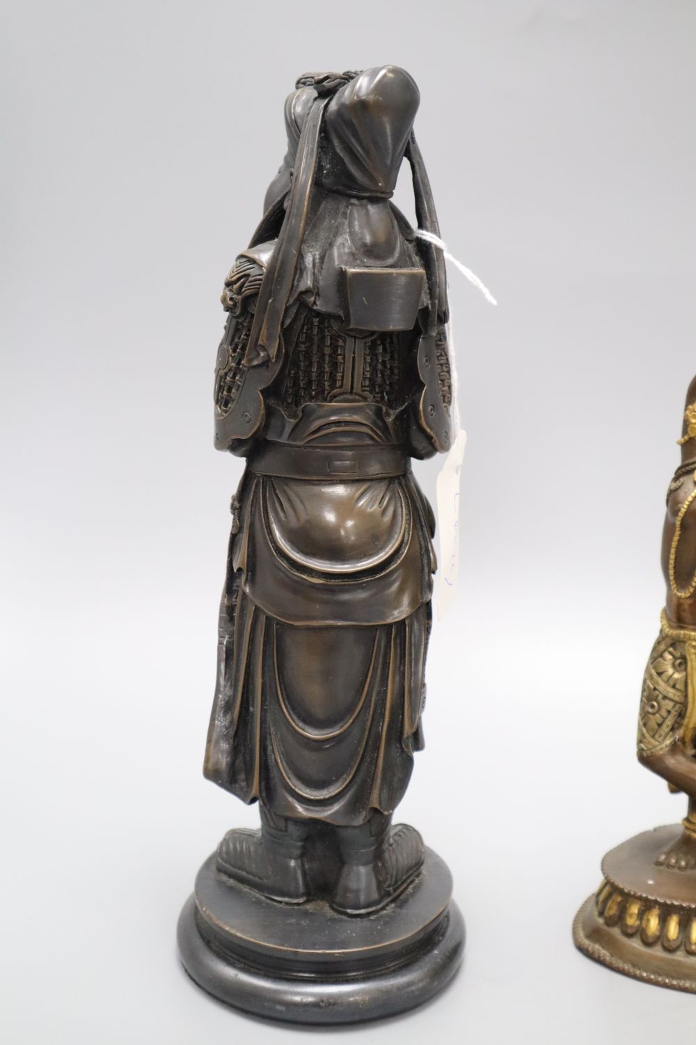 A gilt metal putti playing a musical conch shell, an Indian deity and a sage, tallest 26cm